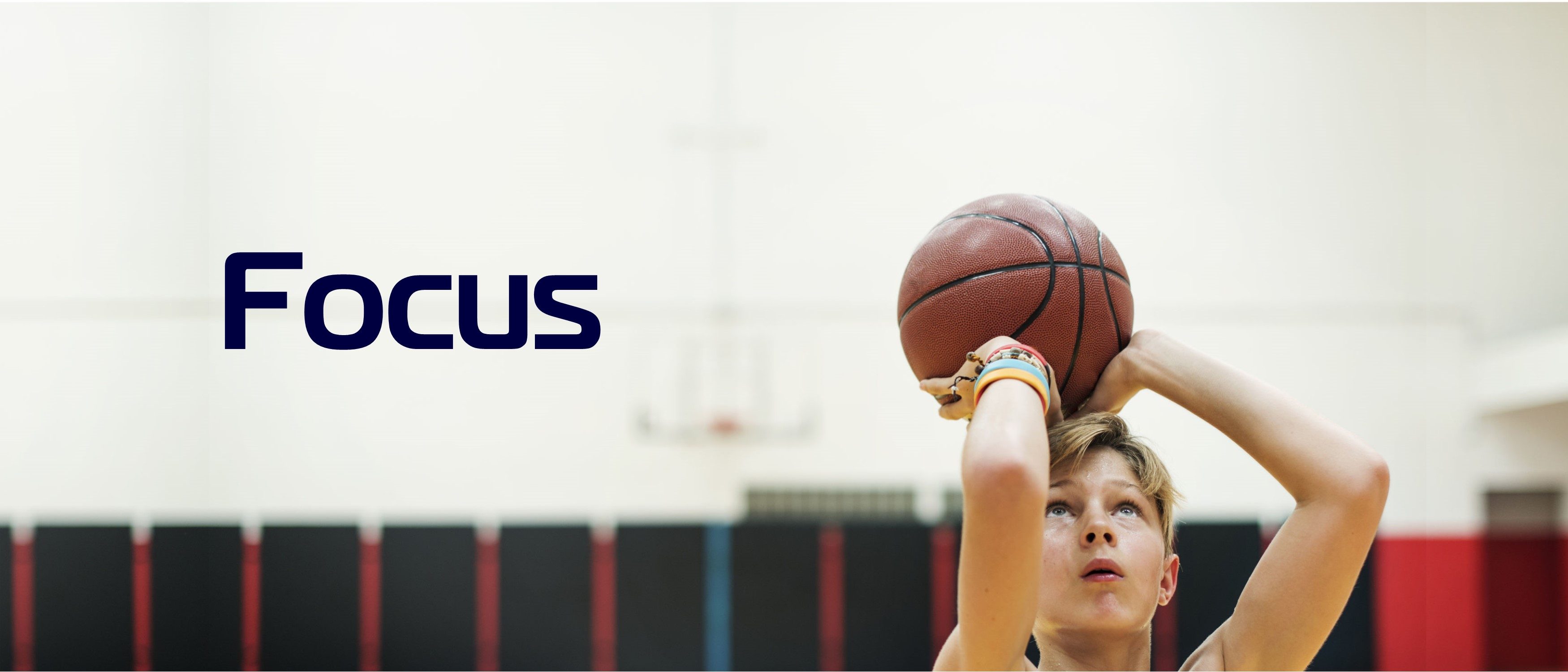 Young athlete holding ball preparing to make basketball shot with Focus text